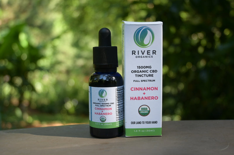 tincture with cinnamon and habanero on the label sat in a garden