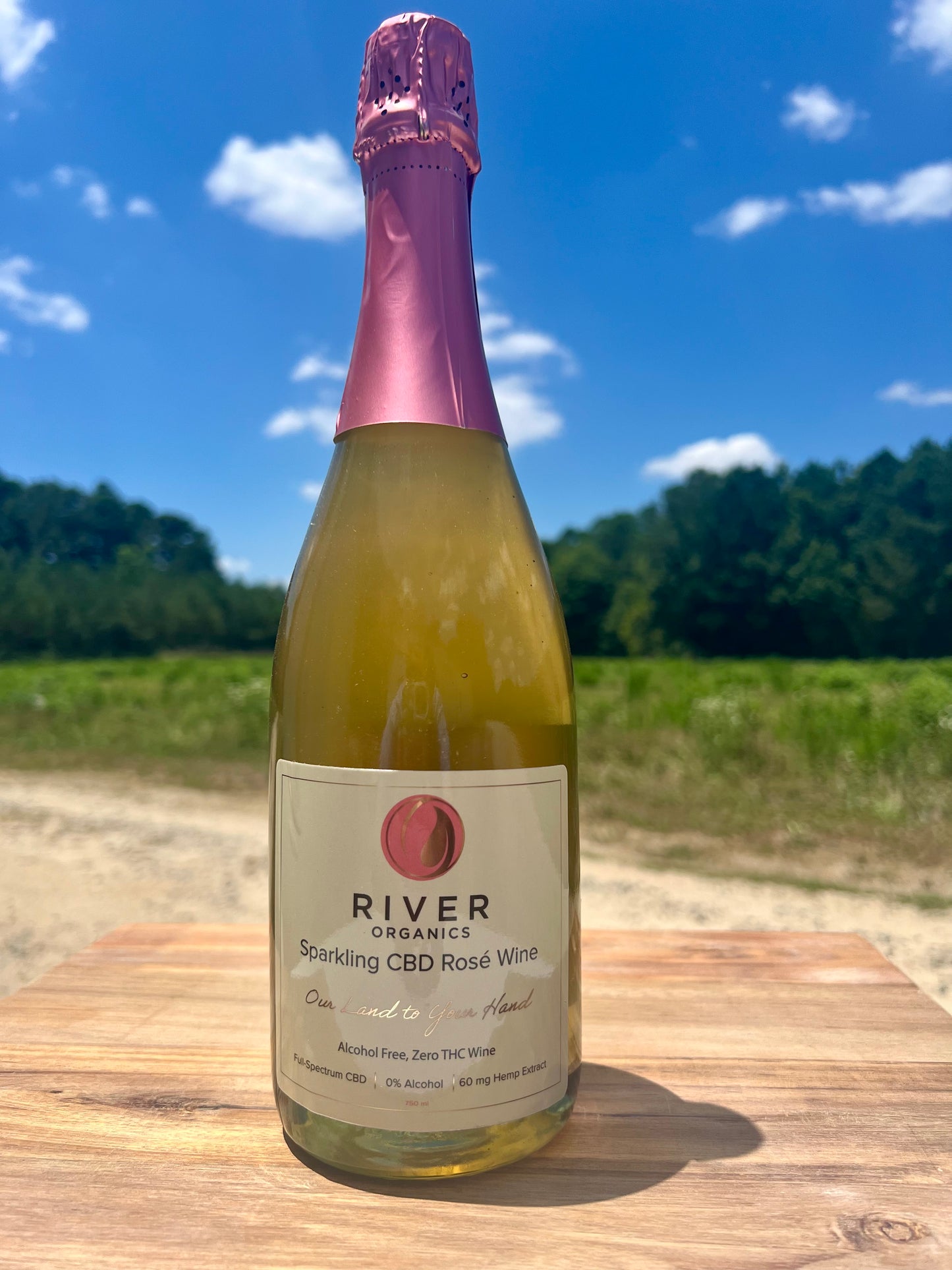 sparkling cbd rose bottle on farm