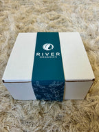 White box with a blue River Organics label on a textured beige surface