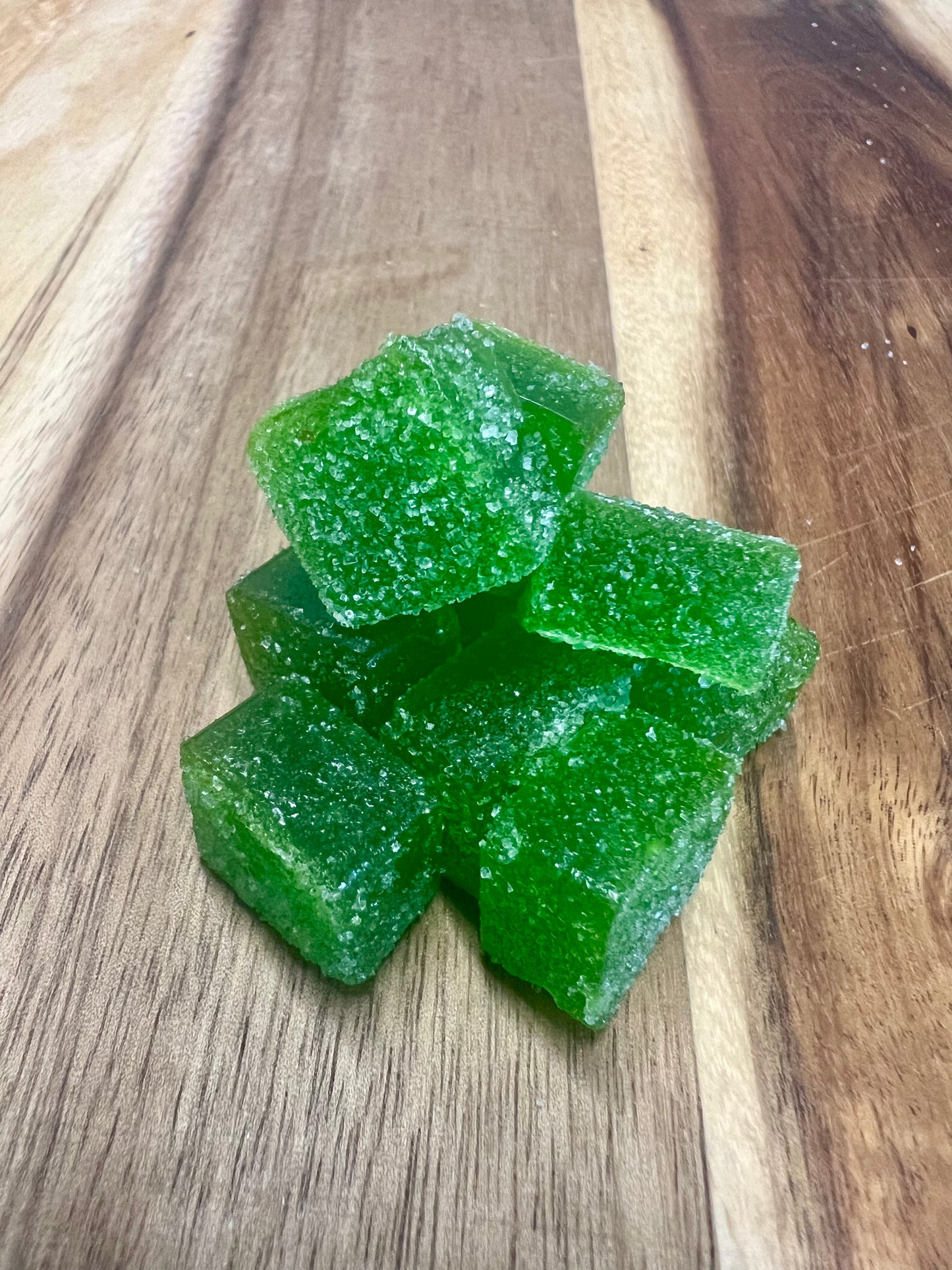 Green Apple cbd gummies on wooden plank