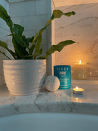 cbd bath bomb in bath with plant and candle